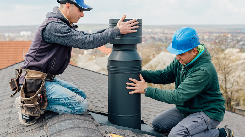 Two,Professional,Workmen's,Standing,Roof,Top,And,Measuring,Chimney,Of